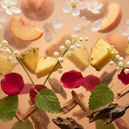 Royale Noir "Sweet Fire" Perfume Ingredients containing Sliced peaches, pineapple, oud, and flowers on a beige background