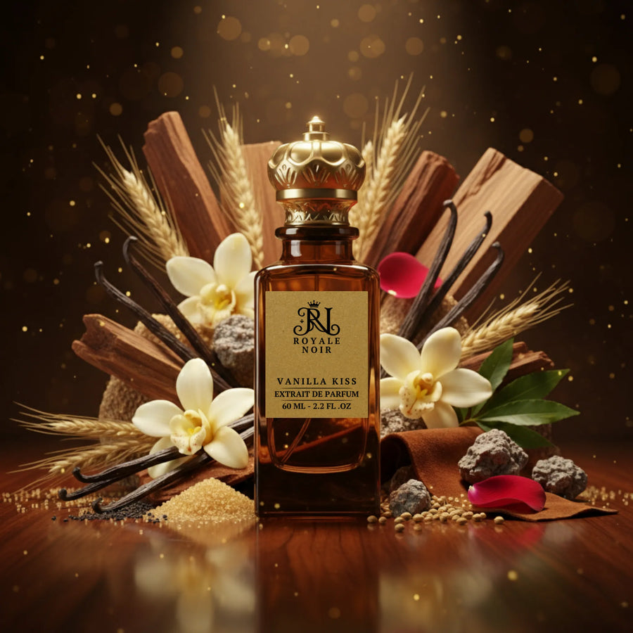 A rich brown bottle of Royale Noir's "Vanilla Kiss" Extrait de Parfum (60 ML – 2.2 FL. OZ.) with a golden crown cap, surrounded by its key ingredients. The composition includes vanilla pods, brown sugar cubes, plumeria and vanilla flowers, mint leaves, orange slices, wheat, wood shavings, coriander seeds, and soft petals - all arranged on a warm, brown-toned background that reflects the fragrance’s sweet, creamy, and vanilla character.